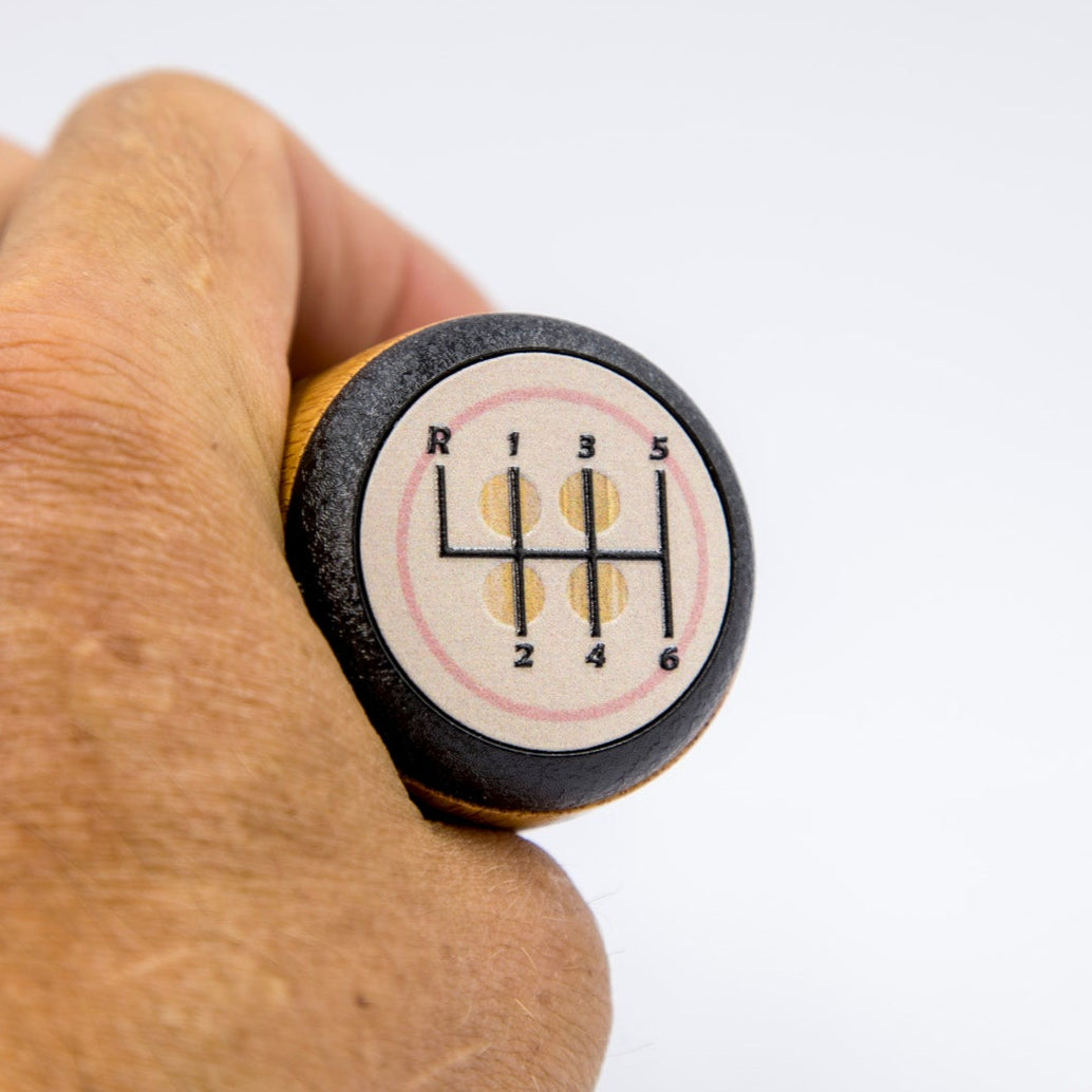 Hand holding a car gear shift knob with a white background