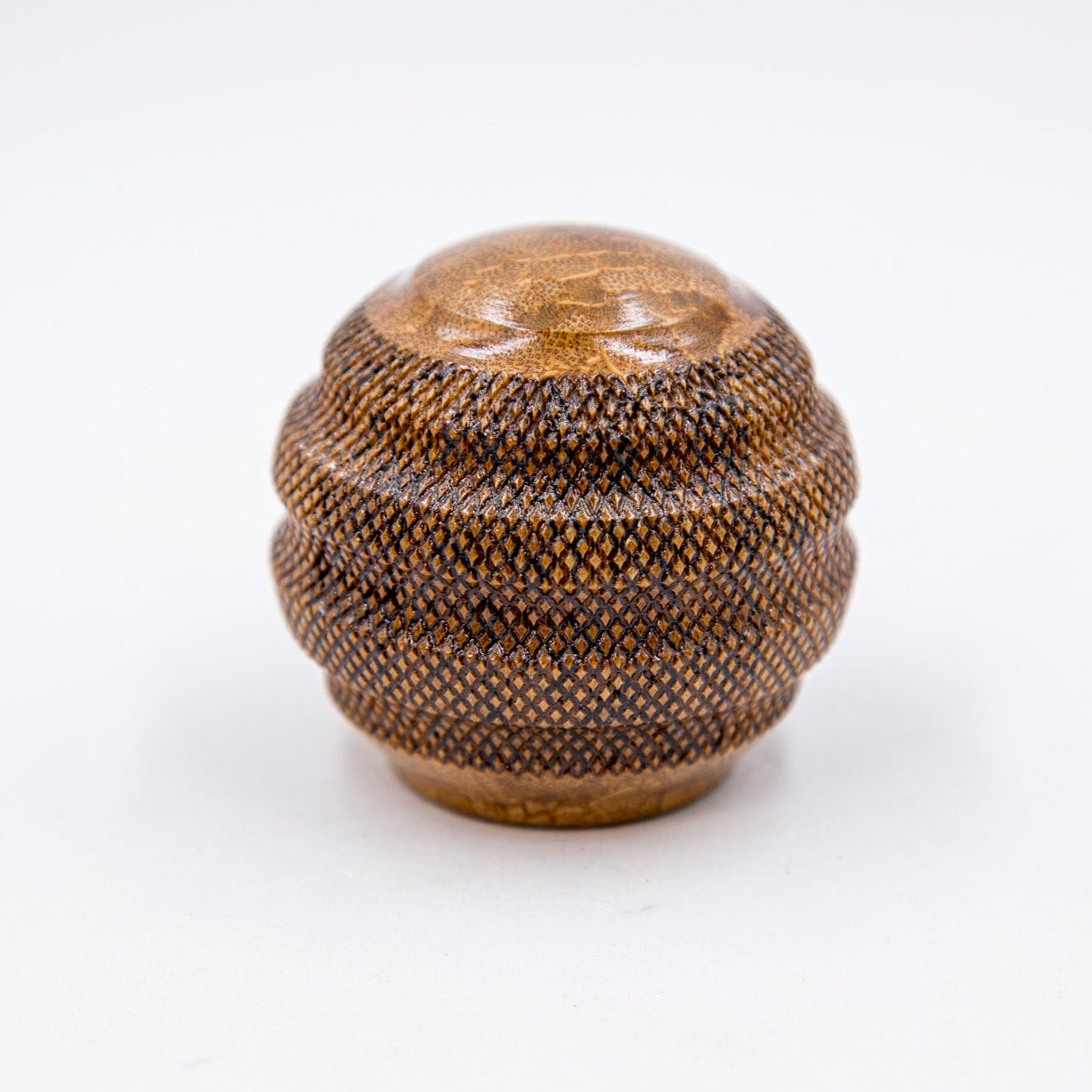 Decorative spherical container with textured surface on a white background
