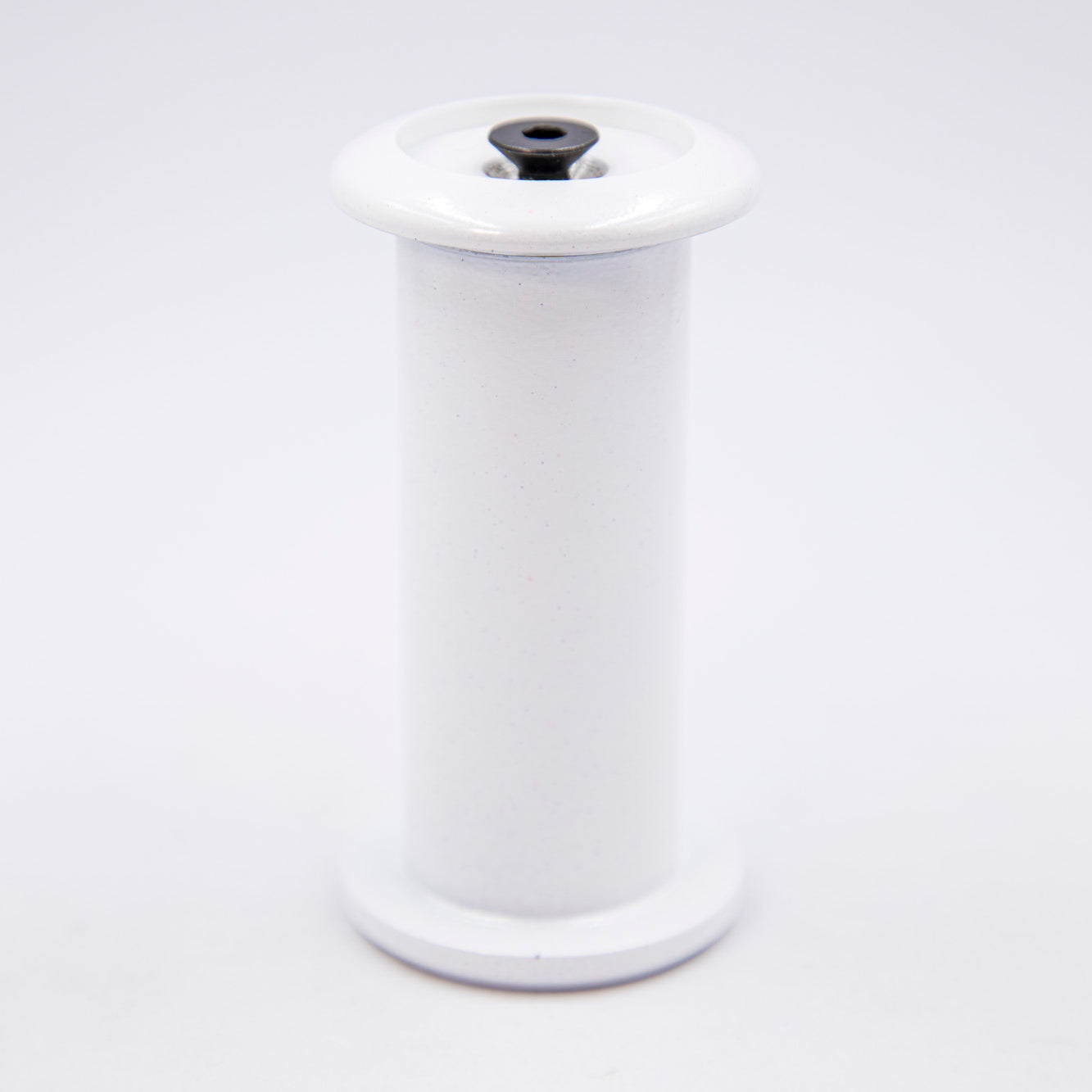 White spool with a black top on a white background