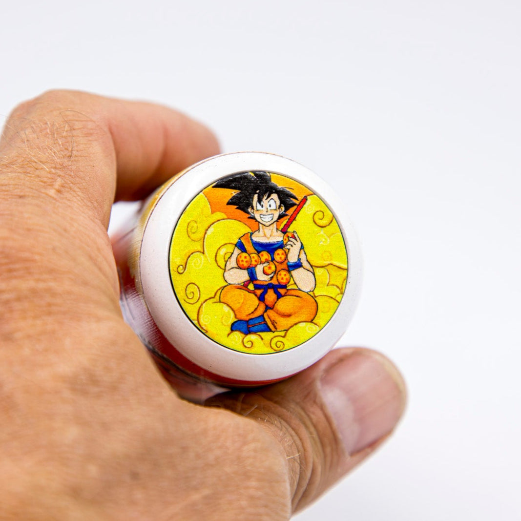Hand holding a round object with a character design on a white background