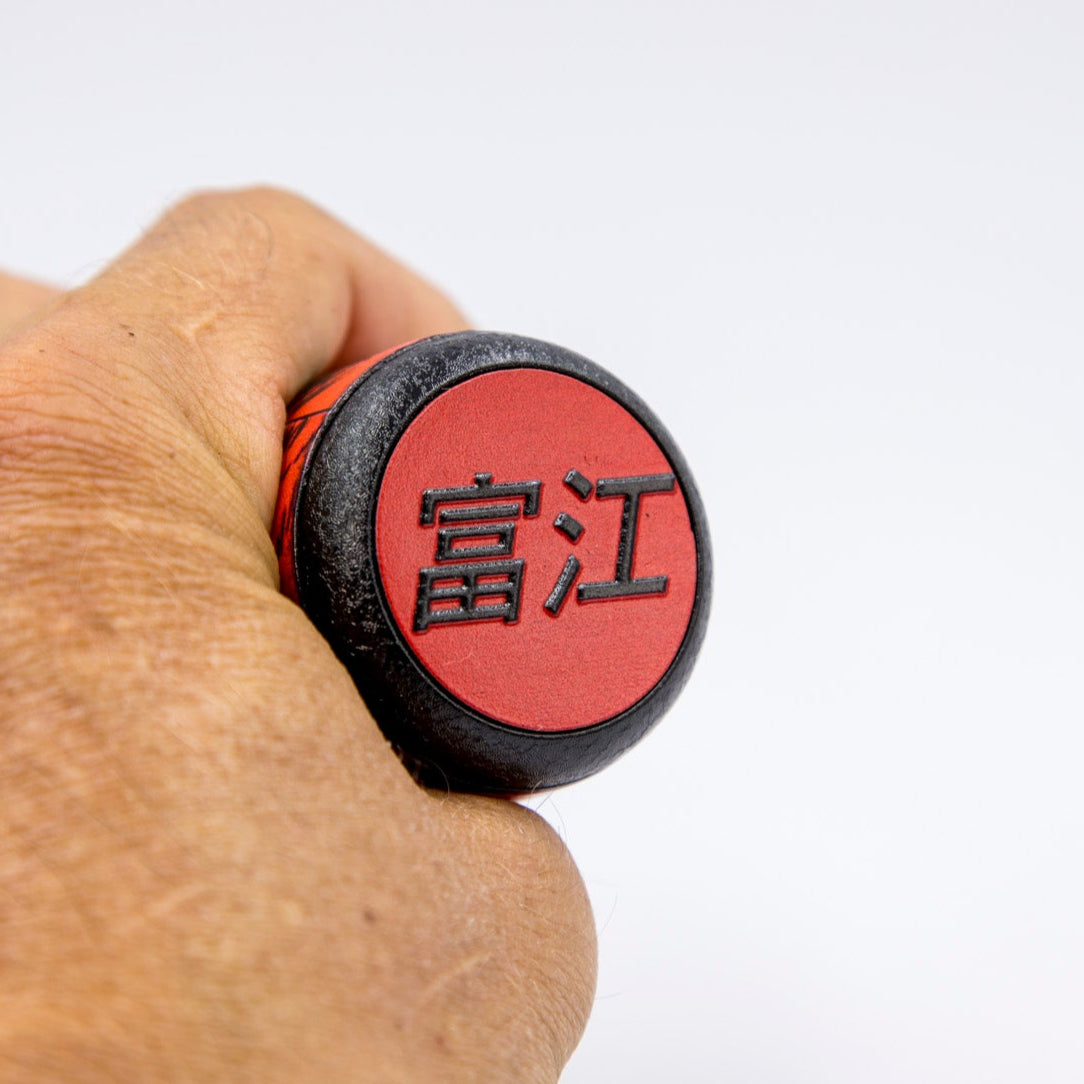 Hand holding a red and black object with Chinese characters on a white background