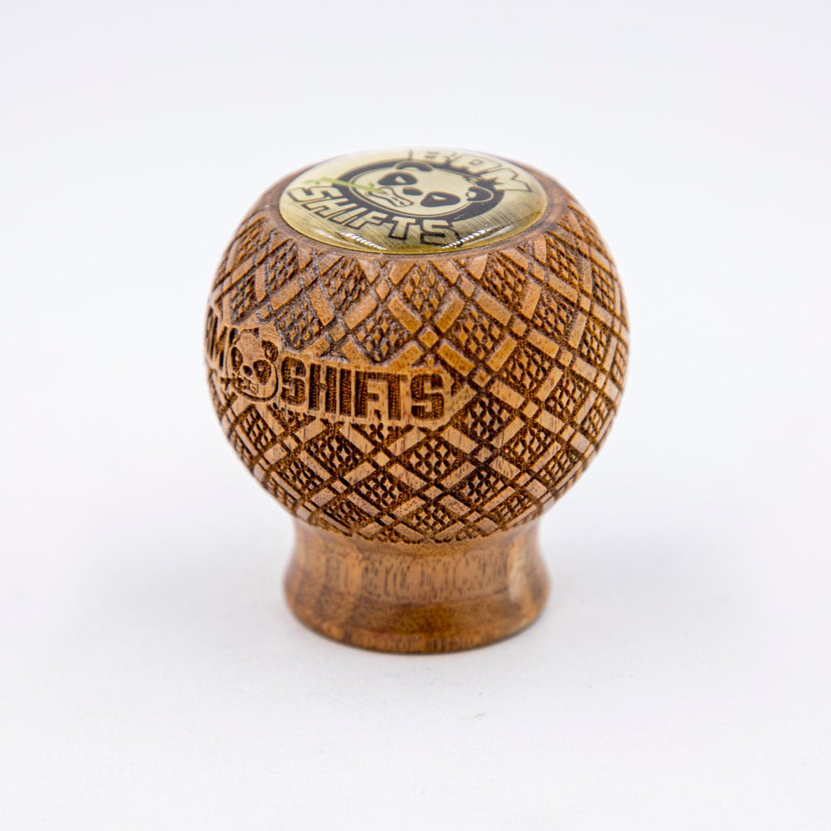 Wooden knob with intricate carvings and 'Shifts' branding on a white background
